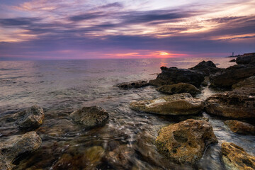Dramatic sunset over beach with a natural pond in the foreground.