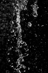 Fototapeta premium water jet with splashes and highlights on a black background