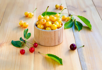 Yellow and red cherry on a wooden table.