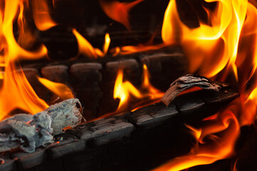 The flame on the wood in the stove, closeup, selective focus.