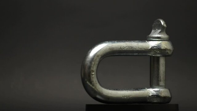 Industrial hook on a rotating plate on a black background for an advertising concept