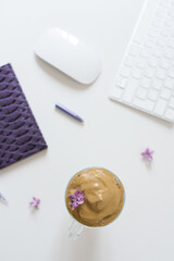 Coffee break at the workplace. Dalgona coffee, Notepad, pen and computer on the table. Top view