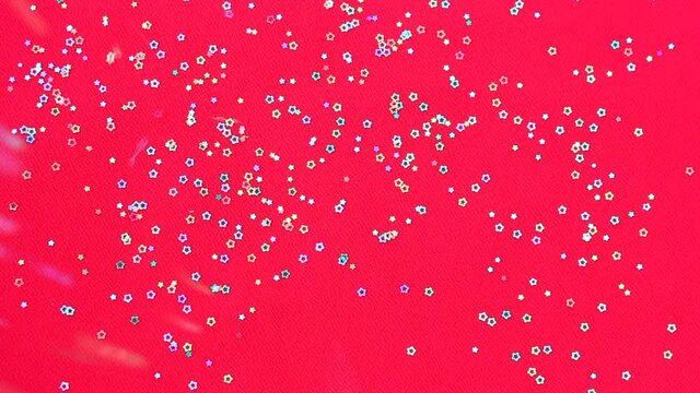 Multicolored shiny glitter confetti dots rain. Golden sparkling glittering border isolated on red background. Party tinsels shimmer, holiday background design, festive frame