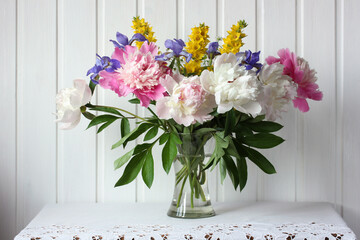 bouquet of garden flowers on the table, peonies and irises.