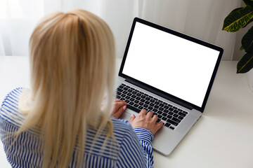 Female hands typing on a laptop keyboard with isolated screen in a white room on a desk