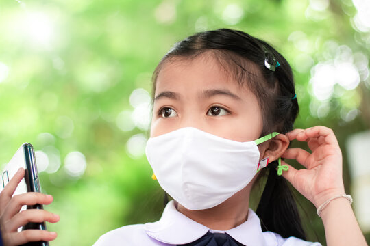 Thai Child Girl Student Wearing Protective Medical Face Mask In School   To Prevent The Outbreak While Back To School ,fighting The Outbreak Of Covid-19 Concept.