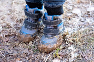 The boy went for a walk in the spring in the forest and got his shoes very dirty