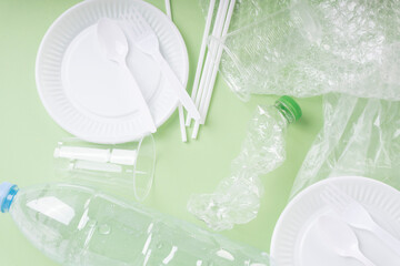 Top view - Plastic waste rubbish over green background.