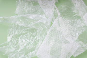 Fototapeta na wymiar Plastic wrap and bag over green background.