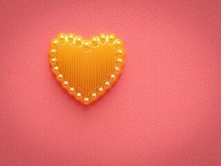 Yellow heart on a pink background.