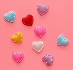 Multi-colored hearts on a pink background.