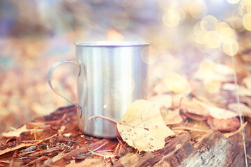 iron mug with hot tea on a camping trip active lifestyle autumn yellow park