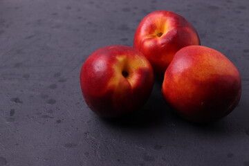red peaches nectarines on black background