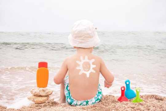 The sun drawing sunscreen on baby (boy)  back.