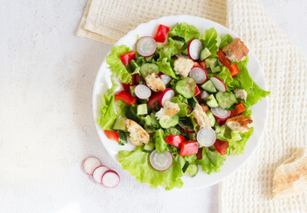 Flatlay. Fattoush salad with vegetables and toasted pita bread on a napkin.