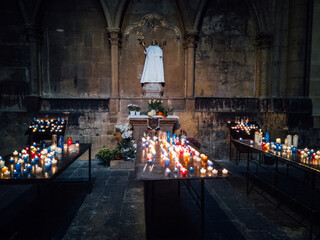 Naklejka premium des bougies dans une église devant un saint.
