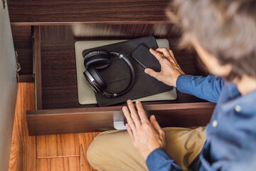 A man puts gadgets in a cabinet for digital detox