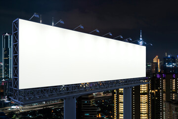 Blank white road billboard with KL cityscape background at night time. Street advertising poster, mock up, 3D rendering. Side view. The concept of marketing communication to promote or sell idea. © VideoFlow