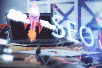 Multi exposure of table with computer and seo drawing hologram. Search optimization concept.