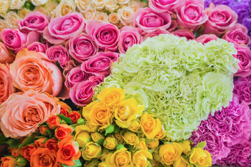 Colorful beautiful flowers wall background - roses and carnations at studio, flower shop - close up view. Floristry, romantic, holiday, birthday, valentine day, wedding, celebration concept