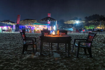 Beach party at night in beach cafe with bottle of rose wine and glasses on the table , GOA, India.. - obrazy, fototapety, plakaty
