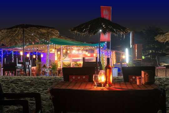 Beach party at night in beach cafe with bottle of rose wine and glasses on the table , GOA, India..