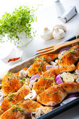 Prepared chicken legs with various vegetables and herbs