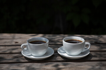 Two cups of coffee filter on a wooden table, side view