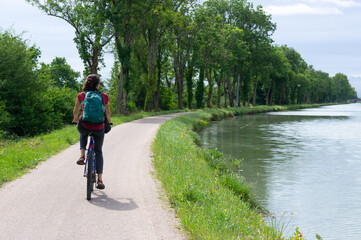 Fototapeta premium Femme à vélo sur le canal des Deux-Mers