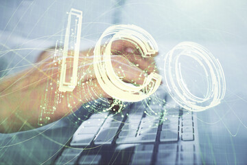 Crypto currency theme hologram with businessman working on computer on background. Concept of blockchain. Multi exposure.