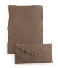 Sheet of paper and natural handmade beige envelope, isolated from the background. contains clipping path
