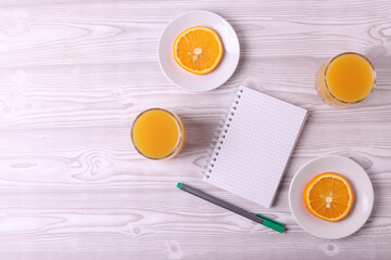 sliced fresh citruses and orange juice on the light rustic wooden surface. top view