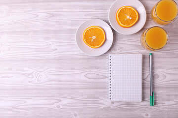 sliced fresh citruses and orange juice on the light rustic wooden surface. top view