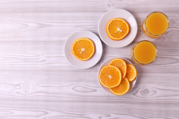 sliced fresh citruses and orange juice on the light rustic wooden surface. top view