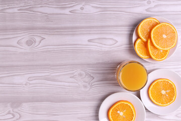 sliced fresh citruses and orange juice on the light rustic wooden surface. top view