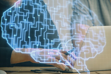 Businessman with computer background with brain theme hologram. Concept of brainstorm. Multi exposure.