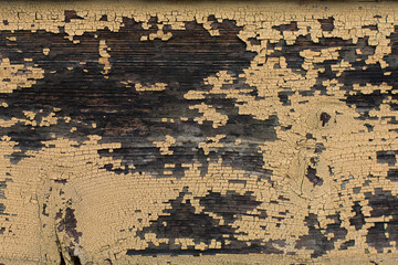 Part of an old wooden board with peeling paint. The boards were painted yellow. The paint cracked...