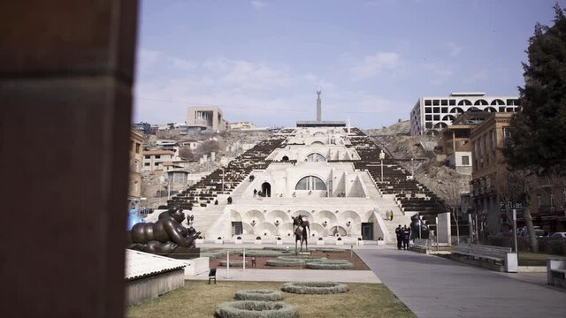 Park in Yerevan with cascade stairs, Armenia. Art. Historical architectural complex with many stairs, fountains, and monuments on blue cloudy sky background.