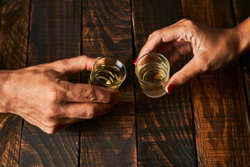 Hands with shot glasses toasting. Concept of alcoholism and addiction. - 361735229