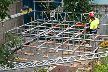 colocando andamios en una fachada &oacute; rehabilitando un edificio por obreros de la construcci&oacute;n