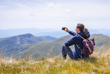 Traveling in nature, woman photographing landscape.