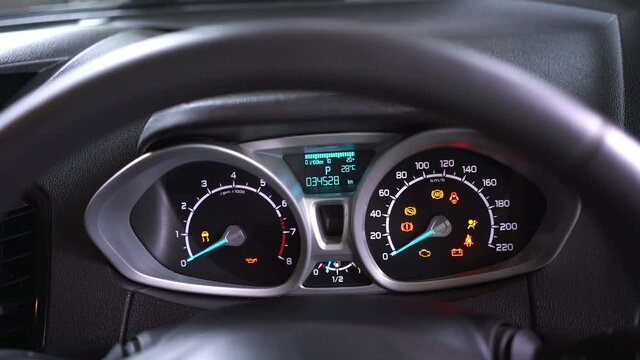 Many different car dashboard lights with warning lamps illuminated.
