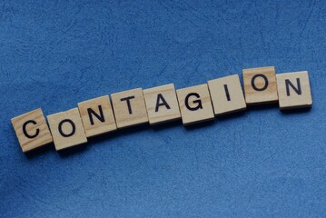  text on gray word contagion in small wooden letters with black font on a blue background