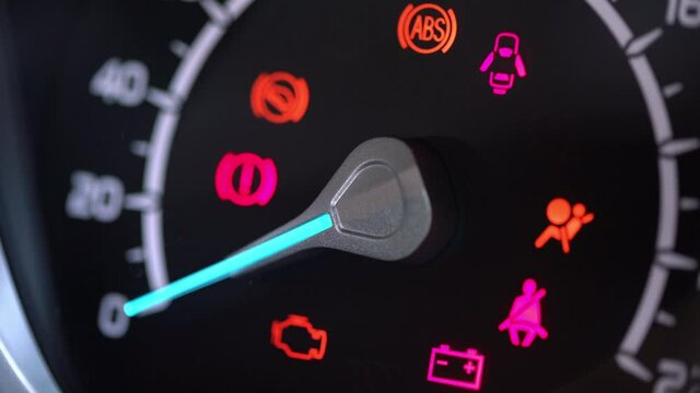 Many different car dashboard lights with warning lamps illuminated.