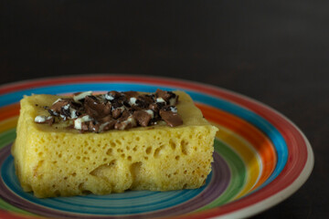 Microwave baked cupcake sprinkled with chocolate on a rainbow plate
