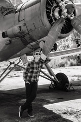 Fototapeta premium A boy stands near an old plane and thinks about flying when he grows up. Old soviet plane. Airplane. screw.