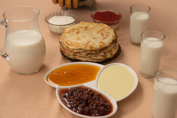 Russian Maslenitsa with pancakes, caviar, condensed milk, jam and milk