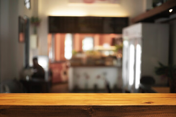Empty wooden desk space and blurry background of cafe or Restaurant for product display montage.