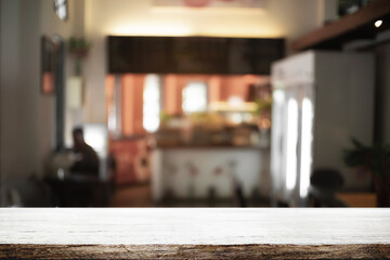 Empty wooden desk space and blurry background of cafe or Restaurant for product display montage.