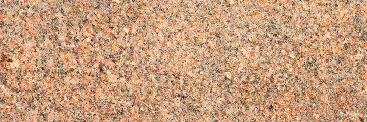 Granite texture. Natural granite with a grainy pattern. Stone background. Solid rough surface of rock. Durable construction and decoration material. Close-up.